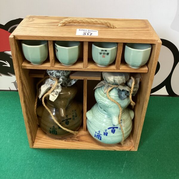 Vintage Japanese sake set with ceramic bottle and cups.