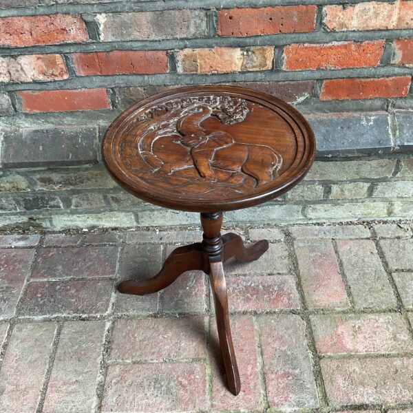 Vintage carved elephant pedestal table with intricate wood detailing.