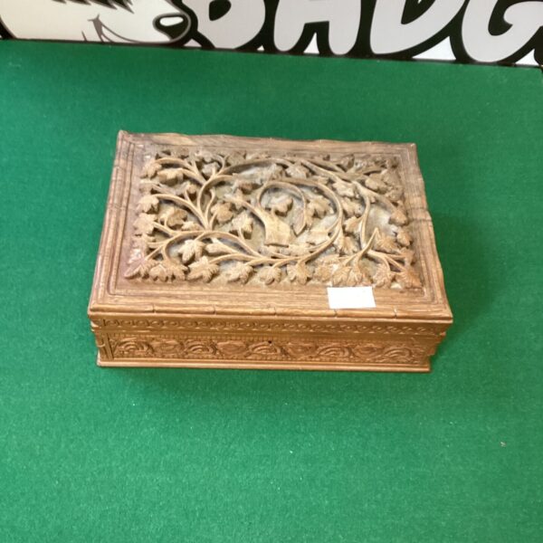 Front view of a vintage carved wooden jewellery box.