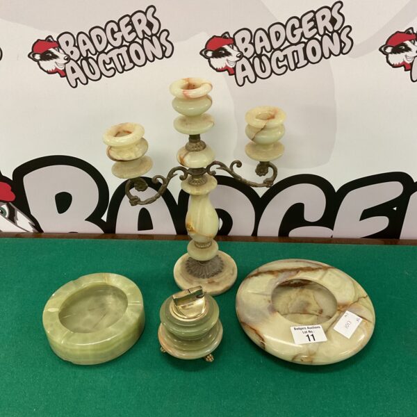 Vintage alabaster candlestick, lighter and ashtrays on display.