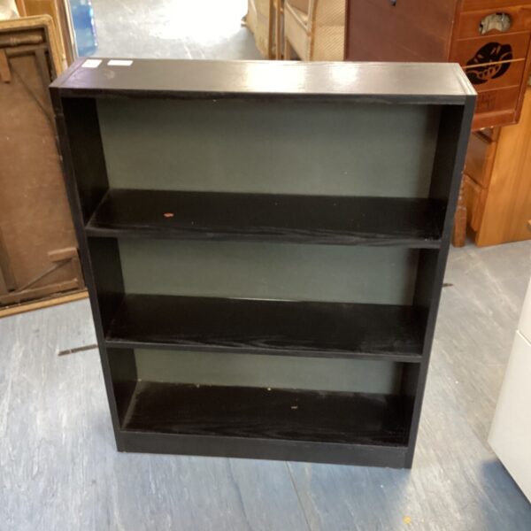 Dark wood bookcase with three shelves for home storage.