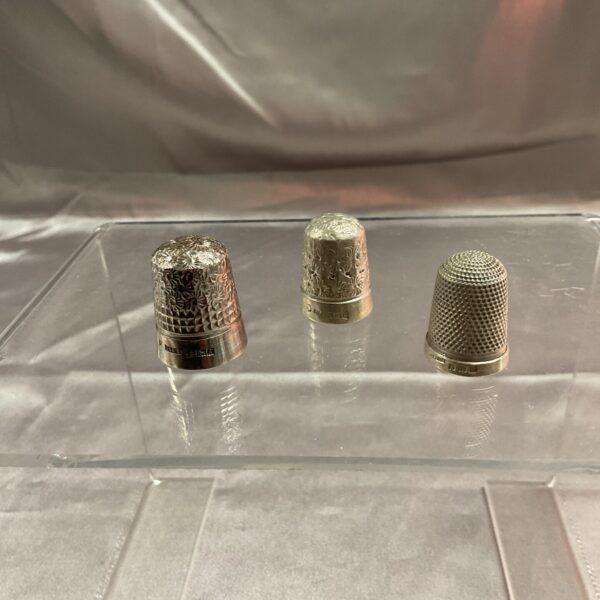 Antique silver thimbles, a collection of vintage sewing tools.
