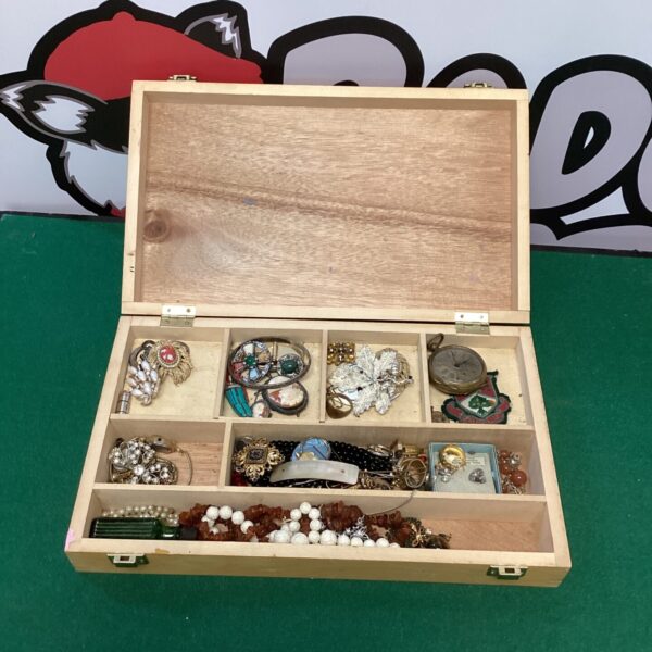 Vintage jewellery box filled with assorted costume jewellery and brooches.