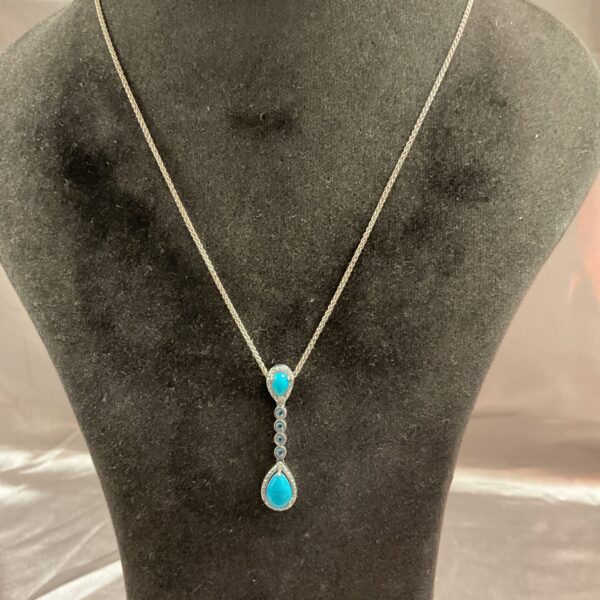 Silver chain pendant with turquoise and blue stone drop.