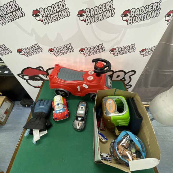 Small plastic ride-on toy car with a box of assorted toys.