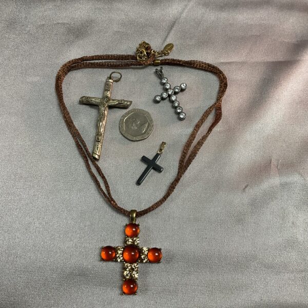 Close-up of a lot of vintage crucifix pendants, including silver.