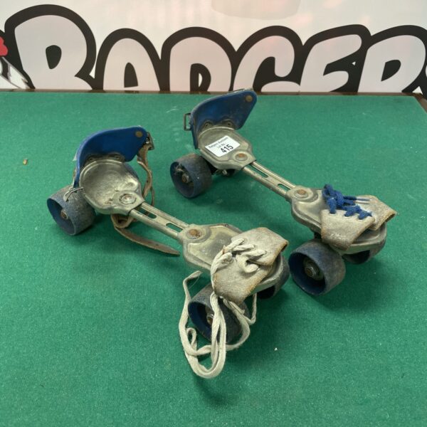 Vintage pair of quad roller skates with leather straps.