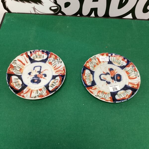 Antique hand painted plates with vibrant floral design.