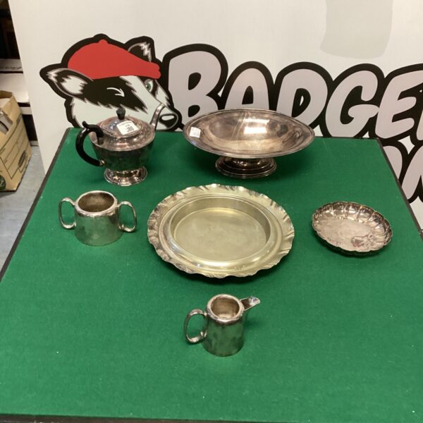 Vintage silverplate tableware set with teapot, creamer, and serving dish.