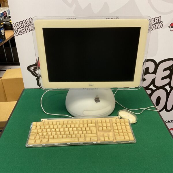 Vintage Apple iMac desktop computer with keyboard and mouse.