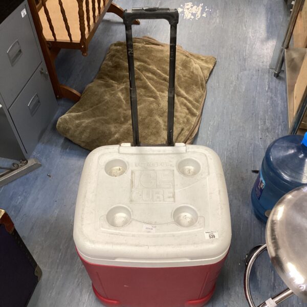 Vintage red and white Igloo cooler box with wheels.