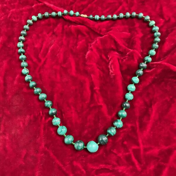 Close-up of a vintage malachite necklace with graduated green beads.