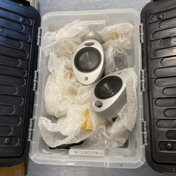 Collection of six KEF mini speakers in a plastic container.