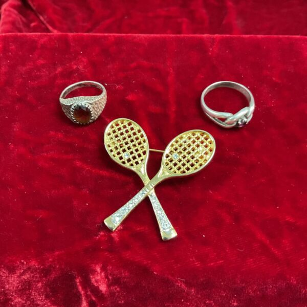 Vintage tennis brooch and stone set rings, a collectible jewellery lot.