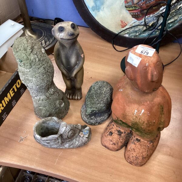 Collection of terracotta garden ornaments including a meerkat and man.