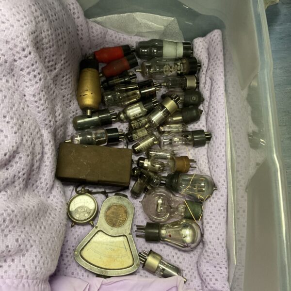 Collection of vintage valves and voltmeters for antique radio restoration.