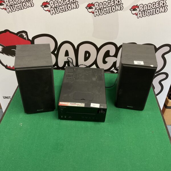 Pioneer CD player system with two speakers on a green surface.