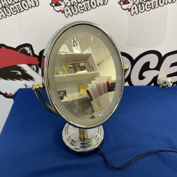 Vintage light-up makeup mirror on a table.