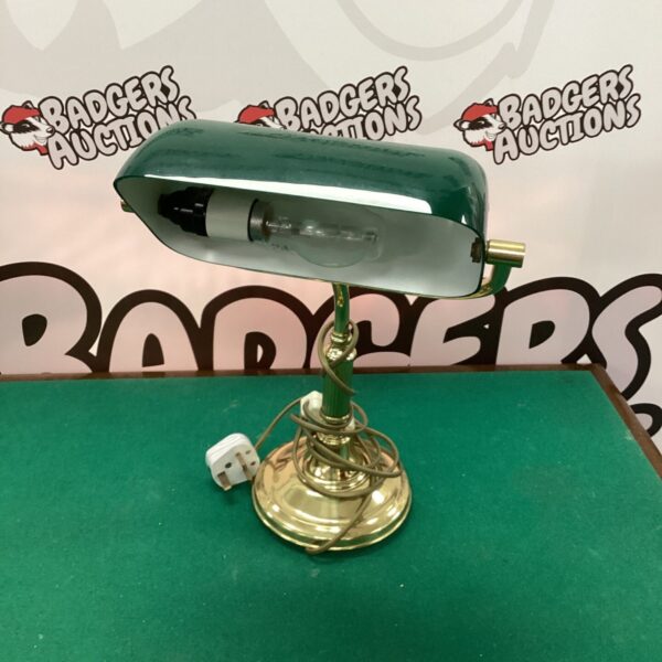 Vintage green glass banker lamp on a desk.