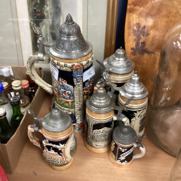 Vintage beer steins collection with pewter lids and ceramic bodies.