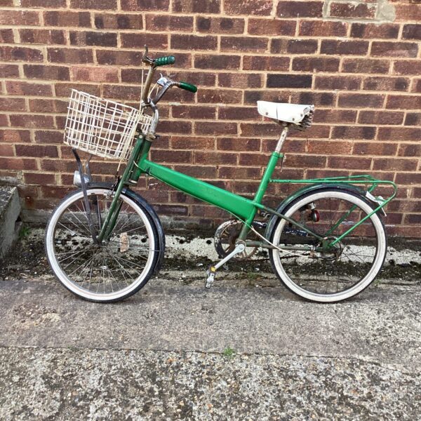 Vintage green ladies bicycle with front basket, classic retro style.
