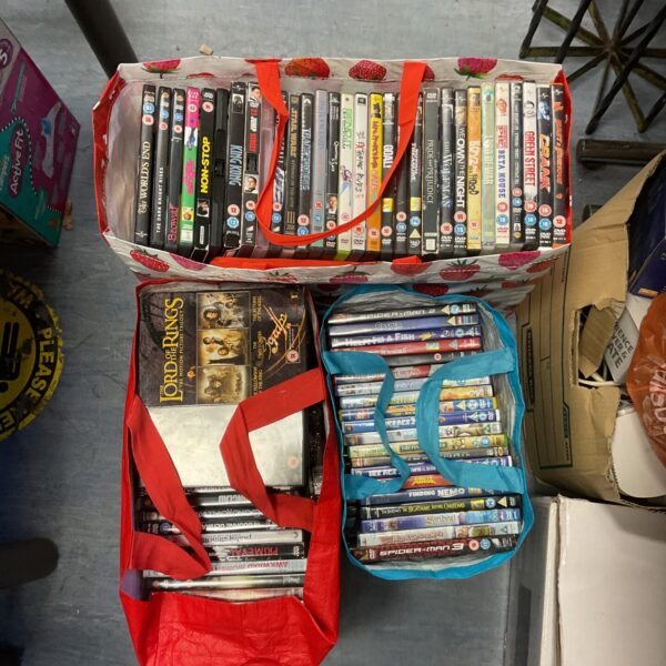 Assorted DVD movies in plastic bags, a large film collection.