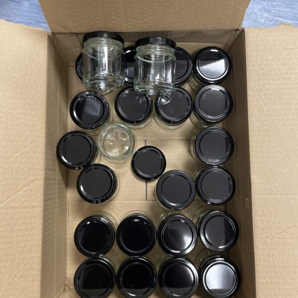Lot of miniature glass preserve jars with lids.