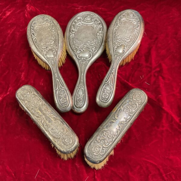 Antique silver dressing table set with mirror and brushes.