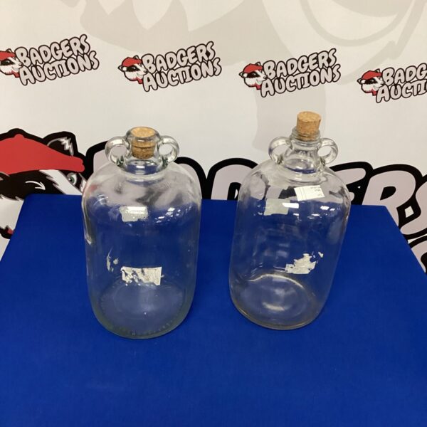 Two clear vintage glass demijohns for fermentation.