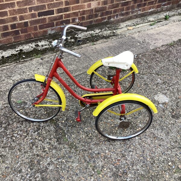 Red and yellow vintage child's tricycle, classic ride-on toy.