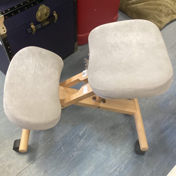 Ergonomic kneeling chair with padded seat and wooden frame.