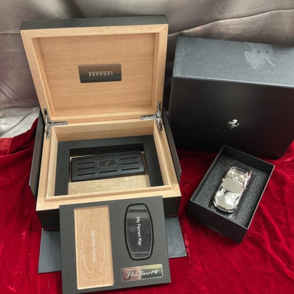 Open Ferrari Portofino key humidor with cigars and documentation.