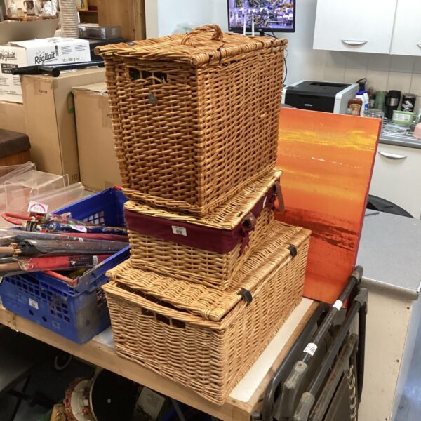 Stack of three graduated wicker baskets for storage.