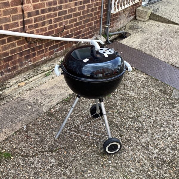 Weber drum barbecue in a garden setting.
