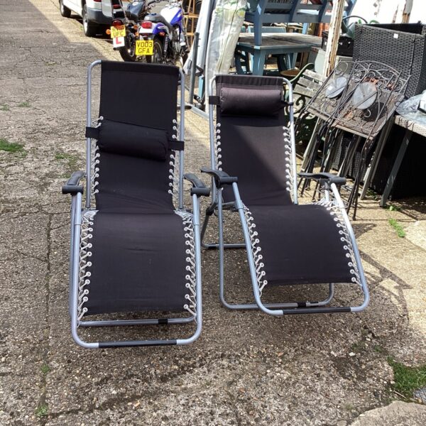 Pair of used garden loungers in a garden setting.
