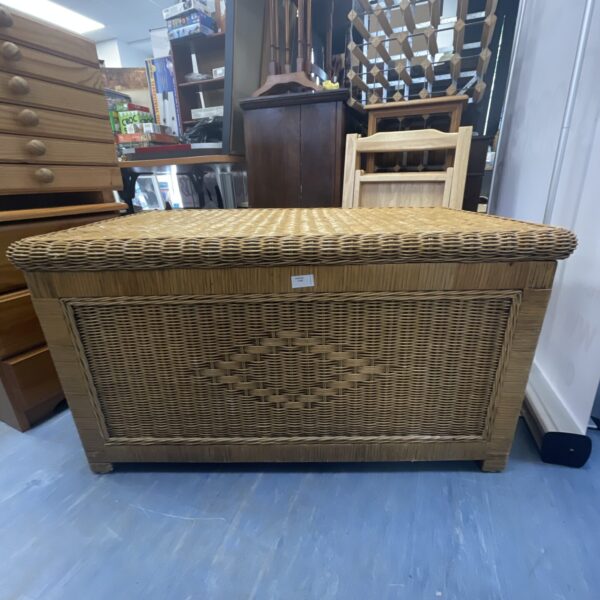 Vintage wicker storage chest with hinged lid, rustic farmhouse style.