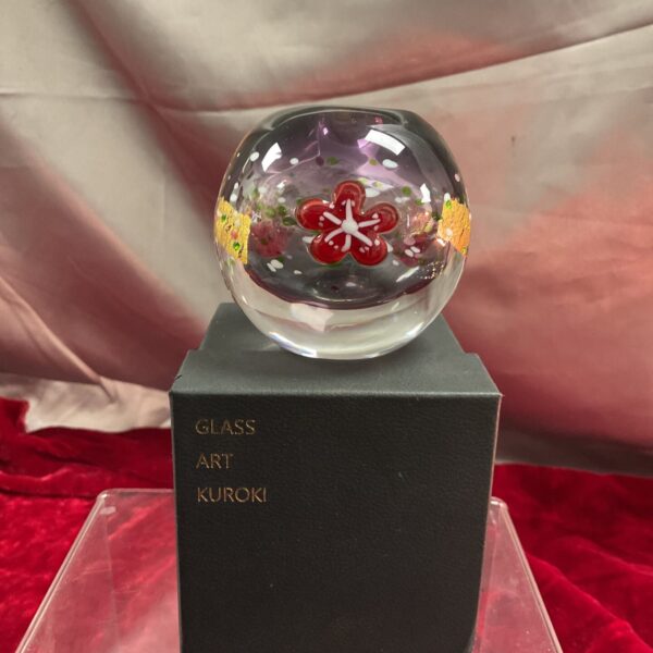 Vibrant Kuroki Kuniaki paperweight with floral design in glass.