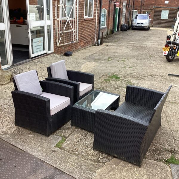 Raffia garden furniture set with table and two chairs on a patio.