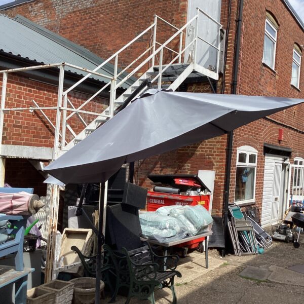 Large garden cantilever parasol with a faded canopy.