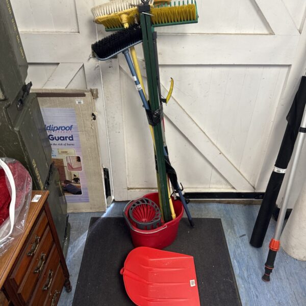 Assorted cleaning equipment lot including brushes and a mop bucket.