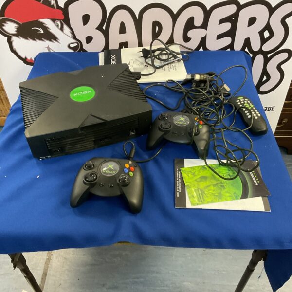 Black original Xbox console with two controllers and DVD adapter.