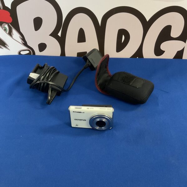 Vintage Olympus FE digital camera with charger and case displayed.