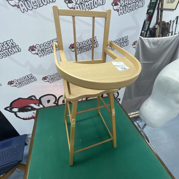 Vintage wooden doll’s high chair, a charming collectible toy.