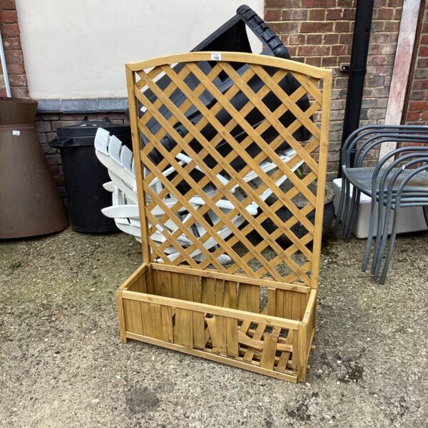 Wooden garden planter with trellis in need of repair.