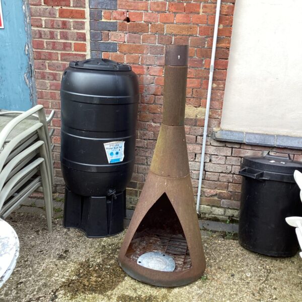 Rustic metal fire pit in a garden setting.