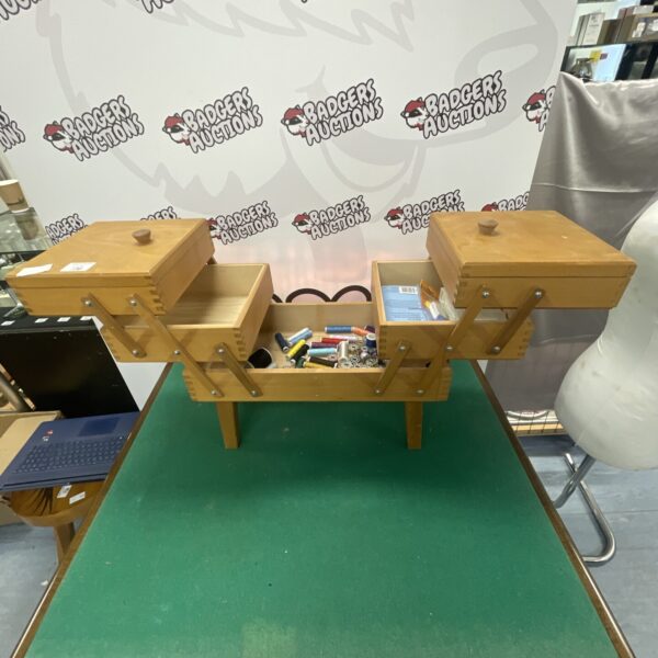 Vintage wooden sewing chest unfolded, showing storage compartments.