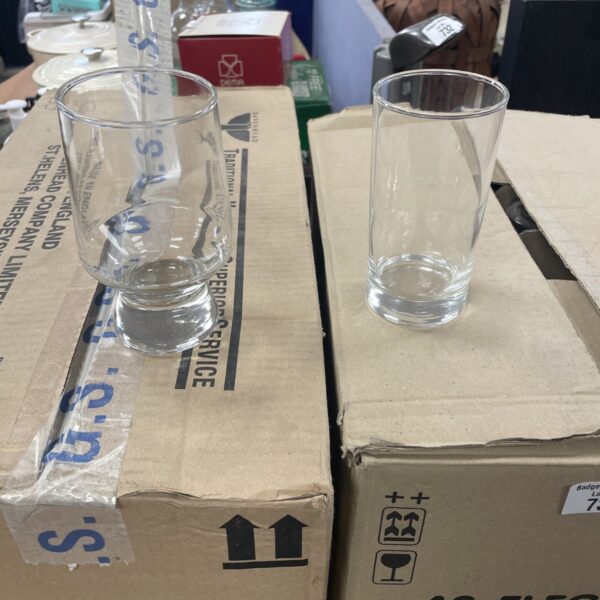 Stack of vintage bar glasses on cardboard boxes.