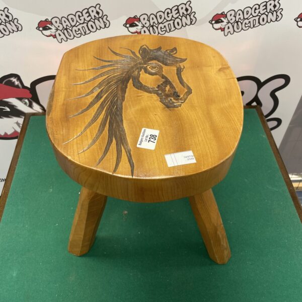 Detailed hand-carved wooden horse stool with rustic charm.