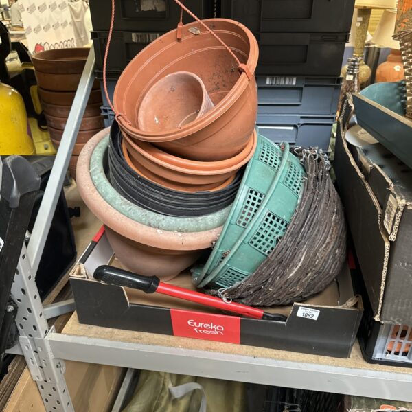 Stack of terracotta garden planters and hanging baskets.