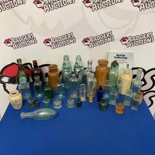 Group of antique and vintage bottles on a blue surface.